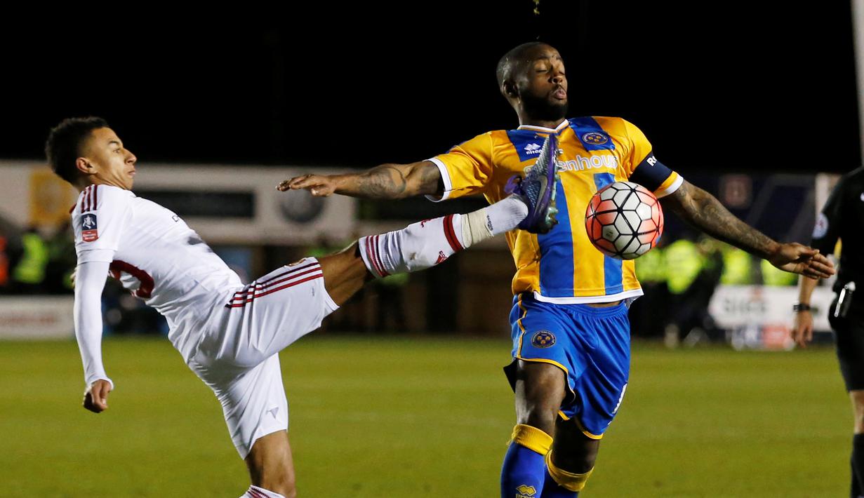 Pemain MU, Jesse Lingar (kiri), berebut bola dengan pemain Shrewsbury Town, Abu Ogogo, pada putaran kelima Piala FA di Stadion Greenhous Meadow, Shrewsbury, Selasa (23/2/2016) dini hari WIB. (Action Images via Reuters/Lee Smith)