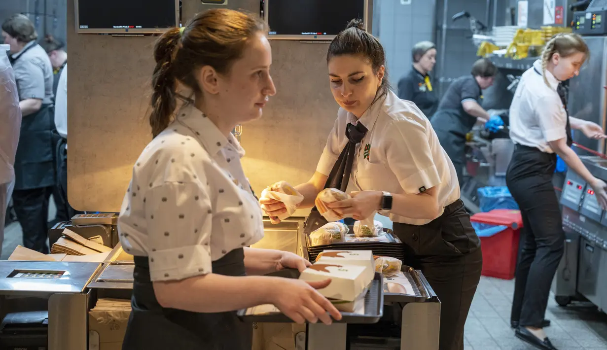 Pekerja bekerja di sebuah restoran cepat saji yang baru dibuka di bekas gerai McDonald's di Bolshaya Bronnaya Street, Moskow, Rusia, 12 Juni 2022. Restoran pengganti McDonald's pertama dibuka di Moskow dengan mereka baru. (AP Photo/Dmitry Serebryakov)