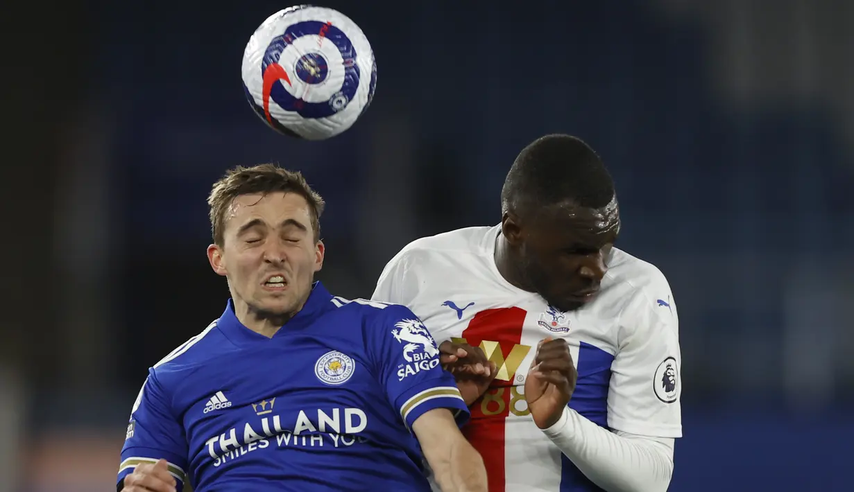 Bek Leicester City, Timothy Castagne dan penyerang Crystal Palace, Christian Benteke berebut bola dalam lanjutan Premier League digelar di King Power Stadium, Selasa (27/4/2021) dini hari WIB. Leicester City memetik kemenangan penting 2-1 di kandang atas Crystal Palace. (Adrian Dennis/Pool via AP)