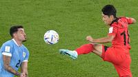 Pemain Uruguay, Jose Gimenez (kiri) berebut bola dengan pemain Korea Selatan Lee Kang-in. (AP Photo/Pavel Golovkin)