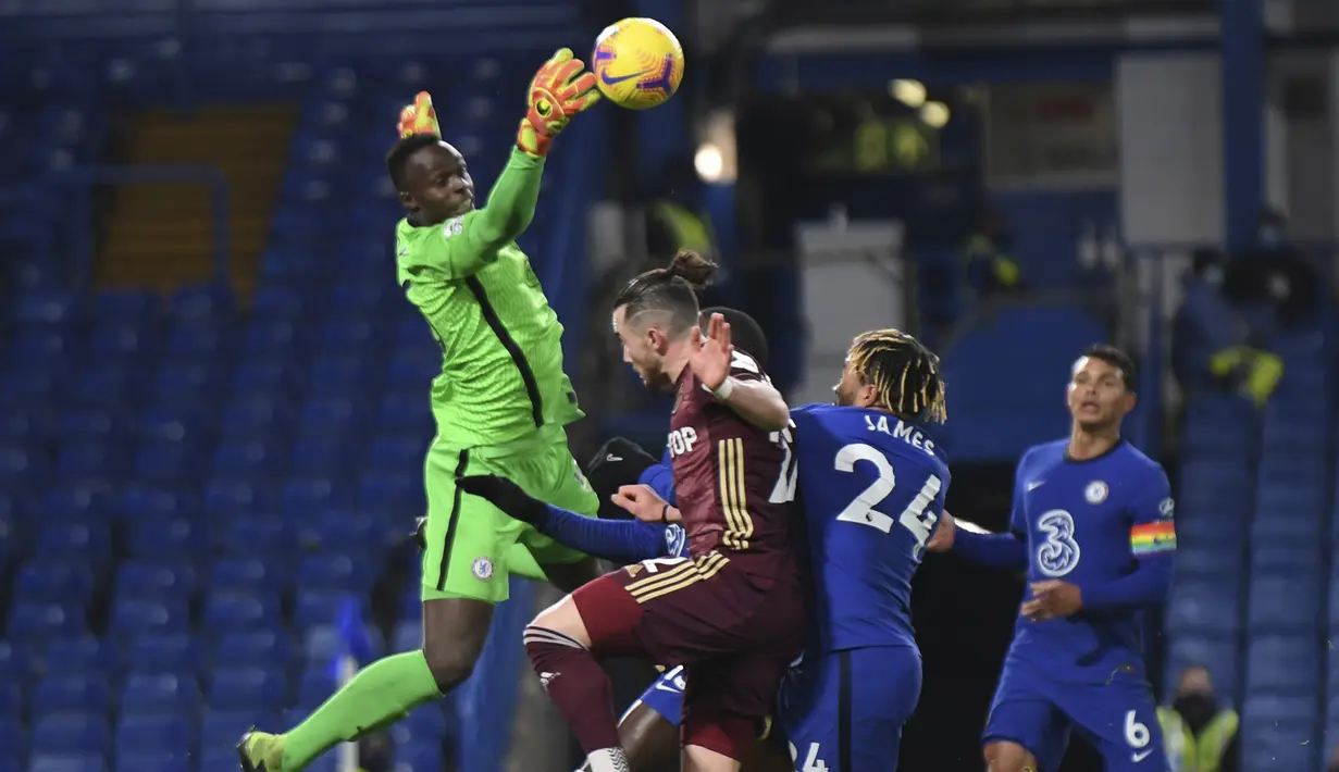 Kiper Chelsea,  Edouard Mendy (kiri) berusaha menepis bola saat bertanding mleawan Leeds United pada pertandingan lanjutan Liga Inggris di Stamford Bridge di London, Inggris, Minggu (6/12/2020). Chelsea menang 3-1 atas Leeds United. (Mike Hewitt, Pool via AP)