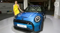 Model berpose di samping mobil MINI Electric Collection pada peluncuran MINI Electric di PIK Avenue Jakarta (08/06/2022). MINI Electric dengan motor listrik bertenaga 135 kW/184 hp dilengkapi Baterai lithium-ion khusus memungkinkan jangkauan hingga 232 km (WLTP) tanpa mengurangi volume kompartemen bagasi. (Liputan6.com/Fery Pradolo)