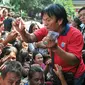 Petugas Vihara Dharma Bakti membagikan angpao dari umat Tionghoa yang datang untuk sembahyang jelang perayaan Imlek, Jakarta, (7/2/2016). Jelang Imlek, ratusan pengemis penuhi Vihara Dharma Bhakti untuk mendapatkan angpao. (Liputan6.com/Yoppy Renato)