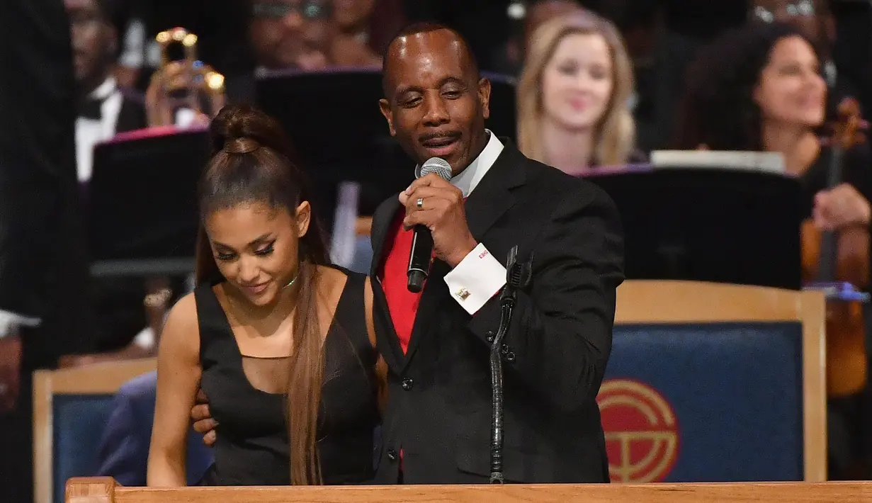 Uskup Charles H. Ellis III merangkul Ariana Grande dalam upacara pemakaman Aretha Franklin di Greater Grace Temple, Detroit, Michigan, AS, Jumat (31/8). (ANGELA WEISS/AFP)