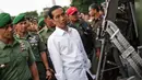 Presiden Jokowi memperhatikan sebuah senjata saat di Pameran  Alutsista TNI AD, Jakarta, Rabu (17/12/2014). (LIputan6.com/Faizal Fanani)