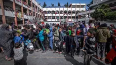 Anak-anak Palestina yang mengungsi berkumpul untuk menerima makanan di sebuah sekolah pemerintah di Rafah, Jalur Gaza selatan pada 19 Februari 2024. (MOHAMMED ABED/AFP)