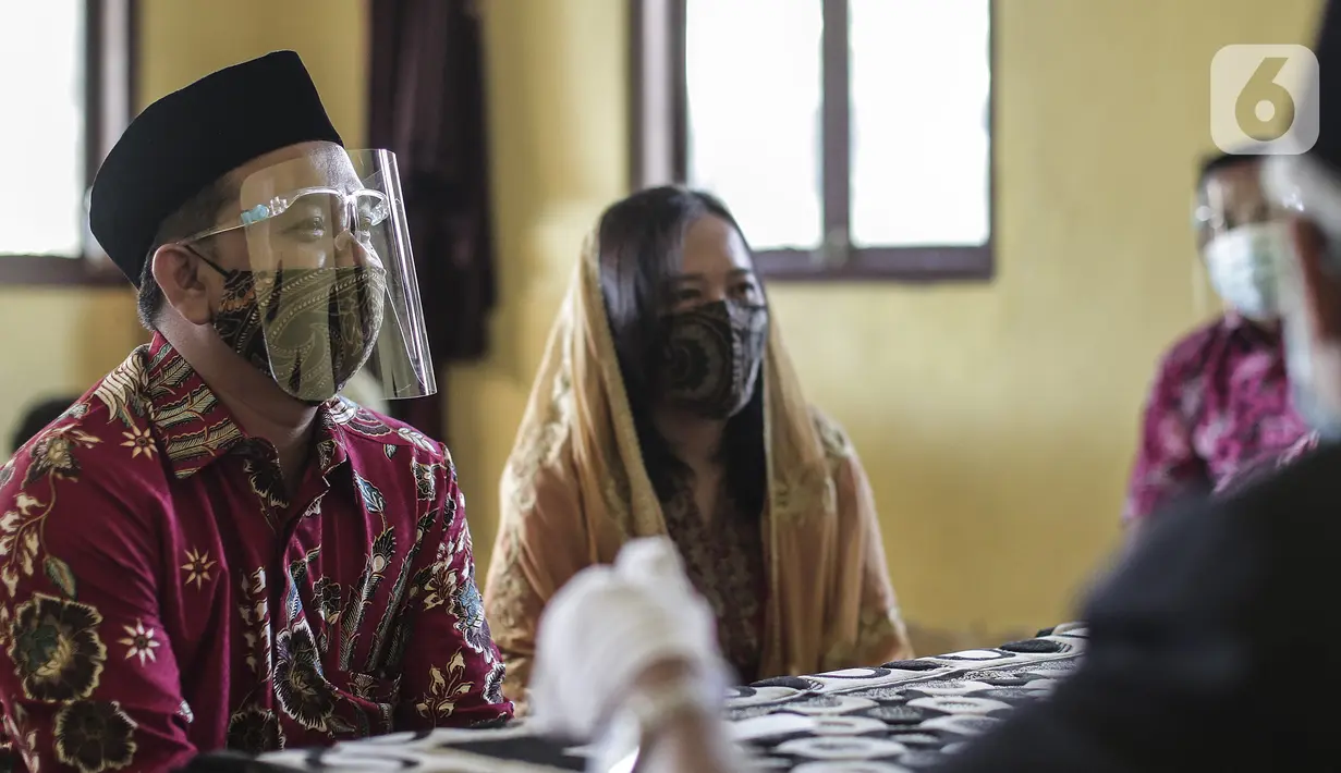 Pasangan pengantin menjalani prosesi akad nikah di KUA Pondok Pinang, Kebayoran Lama, Jakarta, Jumat (17/7/2020). Di masa PSBB transisi, pihak KUA menikahkan 8-10 pasangan per hari dengan mengikuti protokol kesehatan sesuai Surat Edaran Menteri Agama Nomor 15 Tahun 2020. (Liputan6.com/Johan Tallo)