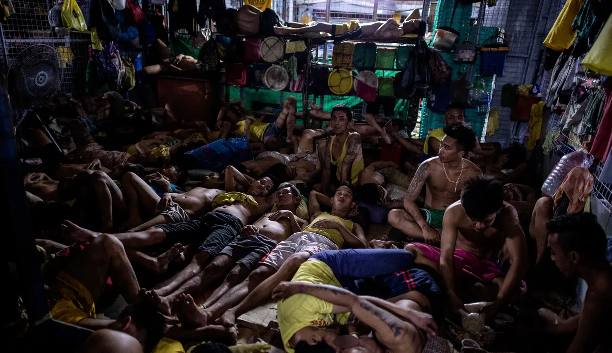 Sejumlah narapidana beristirahat di dalam sel yang berada di penjara Quezon City di Manila, Filipina, 18 Juli 2016. Penjara Quezon City dibangun enam dekade lalu dan menjadi rumah bagi para tahanan yang perkaranya ditunda. (Noel Celis/AFP)