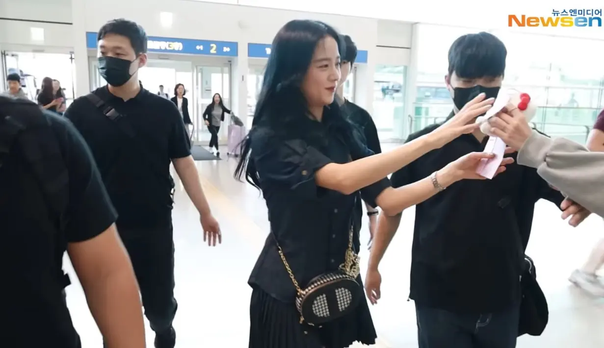 Jisoo juga begitu ramah kepada penggemar. Dia bahkan sempat mengambil hadiah pemberian salah satu fansnya di bandara. (Foto: YouTube/ 뉴스엔·NewsenTV)