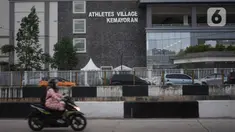 Pengendara motor melintas di depan Wisma Atlet, Kemayoran, Jakarta, Jumat (20/3/2020). Pemerintah akan mengubah fungsi Wisma Atlet Asian Games sebagai rumah sakit darurat khusus penanganan virus corona (Covid-19) sehingga bisa dipakai pada Senin (23/3/2020). (Liputan6.com/Immanuel Antonius)