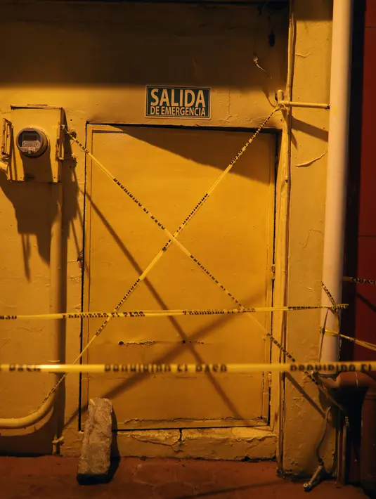 Pintu keluar darurat klub penari telanjang dipasangi garis polisi usai penyerangan di Coatzacoalcos, Veracruz, Meksiko, Rabu (28/8/2019). Gubernur Veracruz Cuitlahuac Garcia mengatakan insiden itu terjadi akibat perkelahian antar geng. (AP Photo/Felix Marquez)