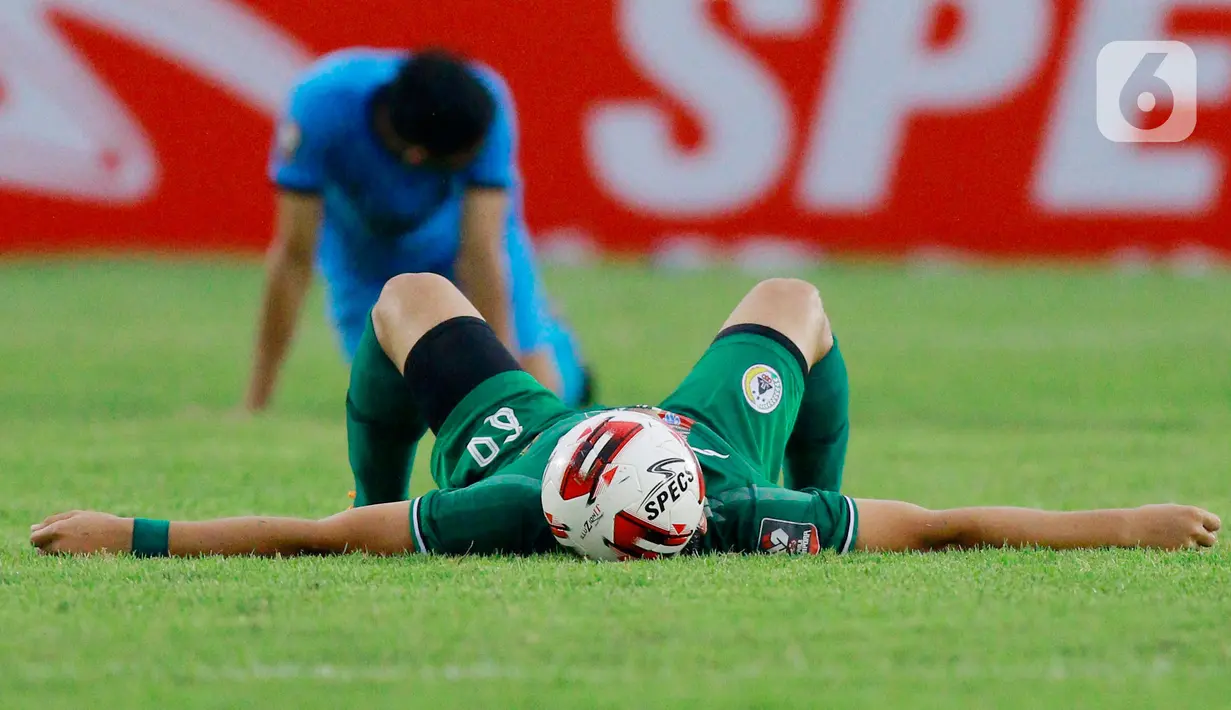 Pemain PSS Sleman, Derry Rachman, tergeletak usai pertandingan melawan Persela Lamongan pada laga Piala Menpora 2021 di Stadion Si Jalak Harupat, Bandung, Minggu (28/3/2021). PSS Sleman bermain imbang atas Persela Lamongan 0-0. (Bola.com/M Iqbal Ichsan)