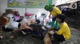 Warga mengumpulkan sampah yang akan dikonversi ke dalam buku tabungan pada salah satu perumahan elite di kawasan Lebak Bulus, Jakarta Selatan, Selasa (21/9/2021). Kegiatan ini sebagai sarana pemanfaatan sampah daur ulang yang dapat menambah pemasukan keuangan keluarga. (merdeka.com/Arie Basuki)