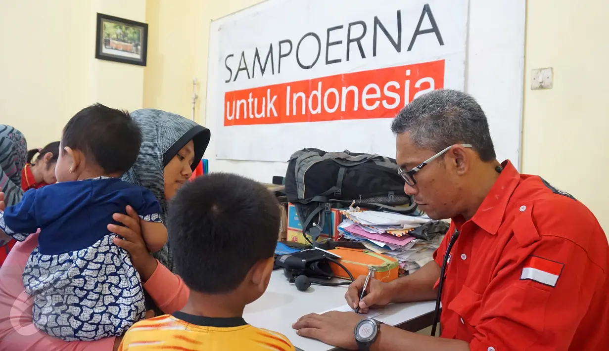 Petugas Tim SAR Sampoerna memeriksa warga korban banjir bandang dan gempa di Bima, Nusa Tenggara Barat (05/1). Kegiatan ini bekerja sama dengan Pemerintah Kota Bima dan Dinas Kesehatan. (Liputan6.com/Istimewa)