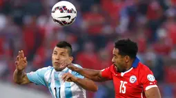 Penyerang Argentina, Sergio Aguero (kiri) berebut bola udara dengan bek Chili, Jean Beausejour di final Copa America 2015 di Stadion Nasional, Chili, (4/7/2015). Chili menang lewat adu penalti atas Argentina dengan skor 4-1. (REUTERS/Marcos Brindicci)