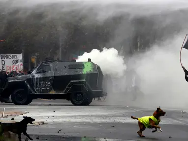 Seorang mahasiswa chili mengibarkan bendera saat bentrok dengan polisi anti huru hara menuntut perubahan sistem pendidikan di Santiago, Chili, 11 Mei 2016. (REUTERS / Ivan Alvarado)