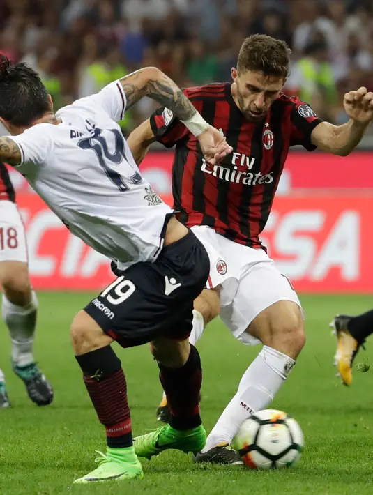 Penyerang AC Milan, Fabio Borini berusaha melewati pemain Cagliari Fabio Pisacane pada lanjutan liga Serie A Italia di stadion San Siro di Milan, (27/8). AC Milan menang atas Cagliari dengan skor 2-1. (AP Photo / Luca Bruno )