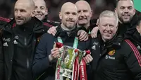 Pelatih Manchester United atau MU Erik ten Hag dan anggota tim berpose dengan trofi juara Carabao Cup 2022/2023 usai kalahkan Newcastle United pada partai final di Stadion Wembley, Senin dini hari WIB (27/2/2023). Ini adalah gelar pertama buat sang manajer Setan Merah Erik ten Hag. (AP Photo/Alastair Grant)