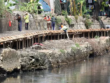 Pekerja mengerjakan proyek pembangunan tanggul bantaran Kali Anak Ciliwung di RT 001 RW 008 Ancol, Pademangan, Jakarta Utara, Kamis (19/12/2019). Pembangunan tanggul untuk mencegah amblesnya bantaran sungai seperti pada akhir tahun 2018 lalu. (Liputan6.com/Johan Tallo)