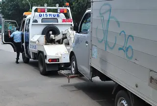 Mobil dari Dinas Perhubungan DKI Jakarta menderek mobil yang parkir di bahu jalan di kawasan Jatinegara, Jakarta, Senin (2/10). Razia ini juga bertujuan untuk memberi efek jera pengendara yang memarkir sembarangan. (Liputan6.com/Helmi Afandi)