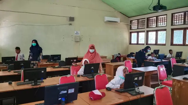 Beberapa siswa SDN Sukun yang masi menyelesaikan simulasi ANBK di SMK Negeri 1 Maumere dan didampingi guru pembimbing. (Liputan6.com/Dionisius Wilibardus)