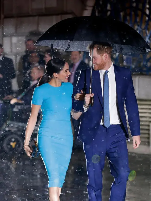 Pangeran Harry dan Meghan Markle sepayung berdua saat tiba di Endeavour Fund Awards, London, Inggris, Kamis (5/3/2020). Hujan lebat turun saat Pangeran Harry dan Meghan Markle tiba di lokasi. (AP Photo/Kirsty Wigglesworth)