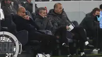 Manajer Manchester City Pep Guardiola duduk di bangku cadangan saat timnya melawan Tottenham Hotspur pada pekan kesembilan Liga Inggris di Tottenham Hotspur Stadium, Minggu (22/11/2020). (Clive Rose/Pool via AP)