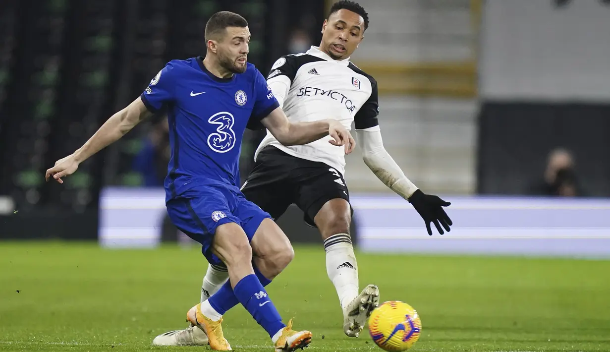 Gelandang Chelsea, Mateo Kovacic bersaing dengan bek Fulham, Kenny Tete pada lanjutan Liga Inggris yang berlangsung di Craven Tottage pada Minggu (17/1/2021) dini hari WIB. Chelsea berhasil meraih kemenangan 1-0 atas Fulham lewat gol tunggal Mason Mount. (John Walton/Pool via AP)