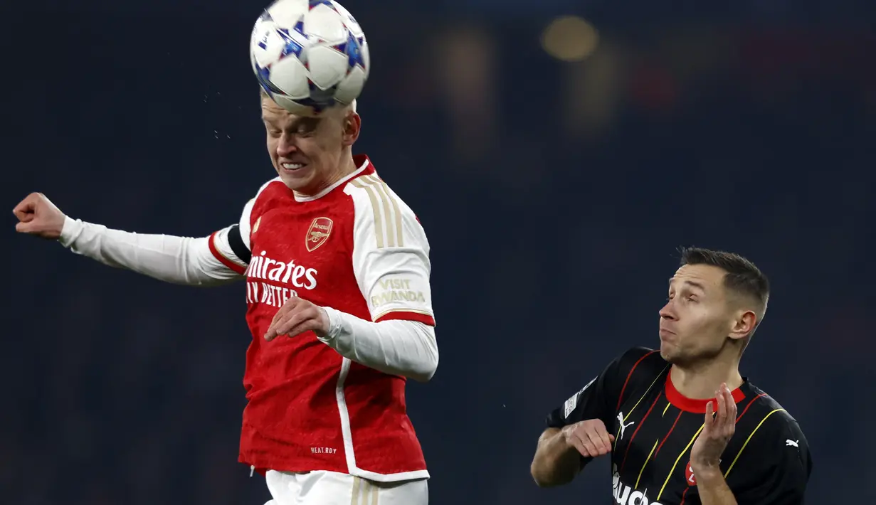 Bek Arsenal #35 Oleksandr Zinchenko (kiri) melompati bek Lens #29 Przemyslaw Frankowski pada matchday 5 Grup B Liga Champions 2023/2024, di Emirates Stadium (30/11/2023) dini hari WIB. (Adrian DENNIS / AFP)