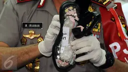 Kapolda Metro Jaya Irjen M Iriawan menunjukkan sandal yang berisi barang bukti narkotika jenis sabu saat rilis di Jakarta, Rabu (27/4). Sebanyak 2.007 gram sabu asal Guangzhou diselundupkan dalam paket lima koli sandal. (Liputan6.com/Helmi Fithriansyah)
