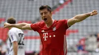 Striker Bayern Munchen Robert Lewandowski merayakan golnya ke gawang Freiburg pada pekan ke-33 Bundesliga di Allianz Arena, Sabtu (20/6/2020). (Sven Hoppe/dpa via AP)