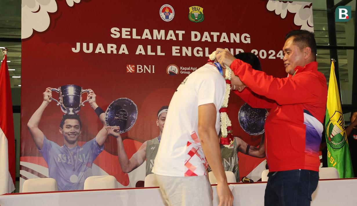<p>Juara tunggal putra All England 2024, Jonatan Christie menerima kalungan bunga dari Sekjen PP PBSI sekaligus Ketua Tim Pokja PBSI untuk Olimpiade Paris 2024, Muhammad Fadil Imran saat acara penyambutan para juara All England 2024 di Terminal 3 Bandara Soekarno Hatta, Tangerang, Banten, Senin (18/3/2024) malam WIB. (Bola.com/M Iqbal Ichsan)</p>