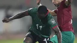 Penyerang Malawi Gabadinho Mhango berebut bola dengan bek Maroko Adam Masina pada babak 16 besar Piala Afrika 2021 di Ahmadou Ahidjo Stadium, Yaounde, Rabu (26/1/2022) dini hari WIB.  Achraf Hakimi menjadi penentu kemenangan Maroko atas Malawi, 2-1. (AP Photo/Themba Hadebe)