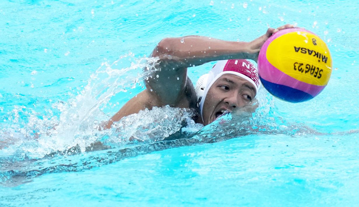 Pemain Tim Polo Air Indonesia, Ahmad Fauzi membawa bola saat melawan Tim Polo Air Kamboja pada nomor polo air putra SEA Games 2023 di Phnom Penh, Kamboja, Jumat (13/05/2023). Indonesia menang telak dengan skor 37-2. (AP Photo/Tatan Syuflana)