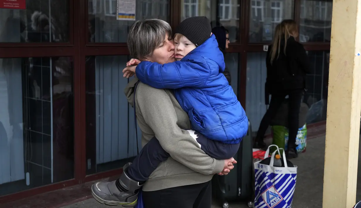 Natalia Pavlyuk memeluk putranya Maksim saat menunggu kereta ke Kharkiv, Ukraina dari Przemysl, Polandia, Rabu (30/3/2022). Menyusul pengumuman Rusia bahwa pasukan mungkin ditarik dari berbagai bagian Ukraina, beberapa pengungsi kembali ke negara asalnya. (AP Photo/Sergei Grits)