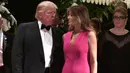 Donald Trump berbincang dengan istrinya, Melania Trump saat menghadiri gala tahunan Palang Merah Amerika ke-60 di Mar-a-Lago, Florida, AS (4/2). (AFP/Mandel Ngan)