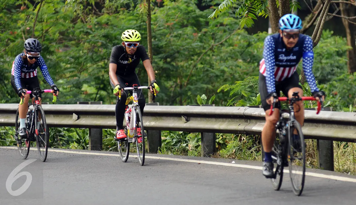 Pebalap sepeda, M Fadli (tengah) saat berlatih di jalan Raya Puncak Cianjur, Bogor, Kamis (23/2). Usai amputasi sebagian kaki kirinya, M Fadli menyatakan pensiun dari balap motor dan menekuni balap sepeda untuk difabel. (Liputan6.com/Helmi Fithriansyah)