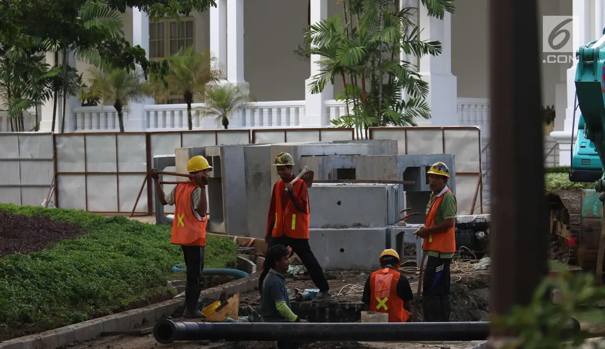 Sejumlah pekerja menyelesaikan perbaikan drainase Kompleks Istana Kepresidenan, Jakarta, Senin (18/12). Pengerjaan rehabilitasi drainase kawasan istana kepresidenan tersebut guna mengantisipasi ancaman banjir. (Liputan6.com/Angga Yuniar)