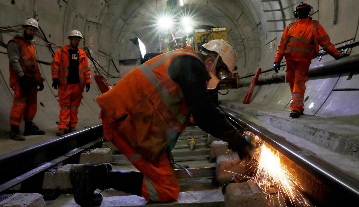 Seorang pekerja mengelas jalur kereta api saat menyelesaikan pembuatan proyek Crossrail di Stepney, London, Inggris, (16/11). Proyek ini memiliki panjang sekitar 180 kilometer. (REUTERS/Stefan Wermuth)
