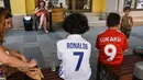 Anak laki-laki yang mengenakan kaus Real Madrid dan Manchester United duduk di bangku di Skopje pada 8 Agustus 2017 menjelang pertandingan sepak bola UEFA Super Cup antara Real Madrid dan Manchester United. (AFP Photo/Armend Nimani)