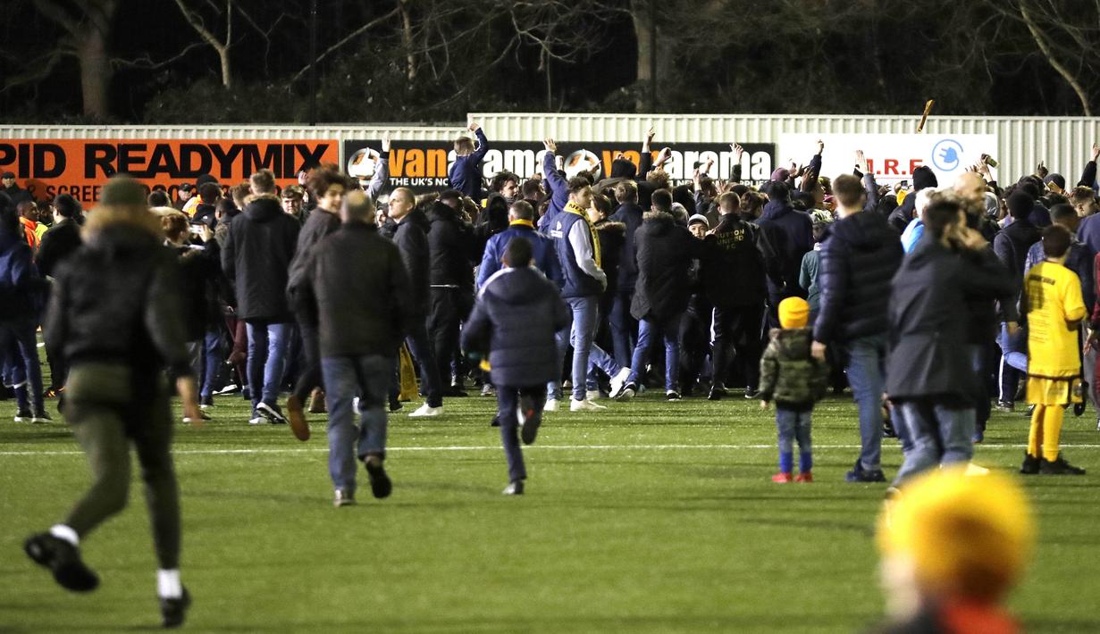 Suporter berlari memasuki lapangan untuk bertemu idola usai Laga Piala FA antara Sutton United melawan Arsenal di Gander Green Lane stadium, London, (20/2/2017). Arsenal menang 2-0. (AP/Matt Dunham)