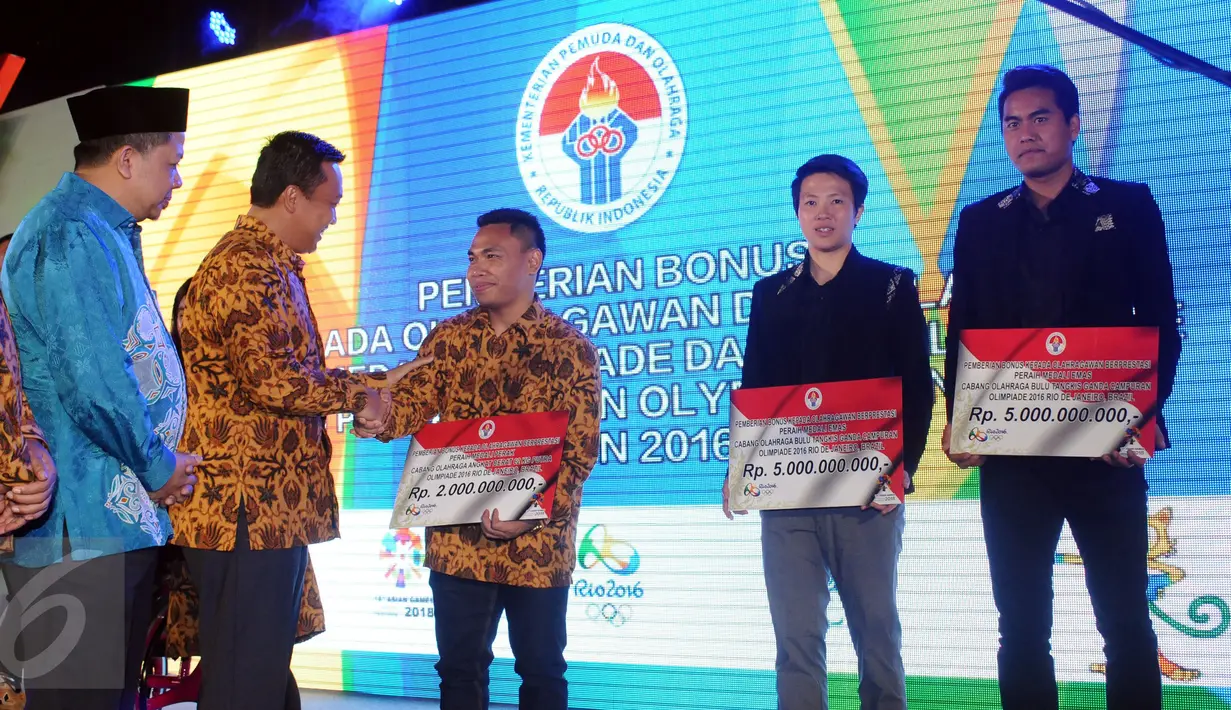 Menpora Imam Nahrawi (ketiga kiri) menyerahkan bonus kepada Eko Yuli Iriawan peraih perak Olimpiade Brasil 2016, Jakarta, Rabu (2/11). Usai menyerahkan bonus, Menpora juga meninjau pembangunan gedung olimpic centre. (Liputan6.com/Helmi Fithriansyah)