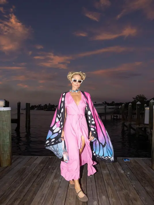 Ia mengenakan gaun maxi merah dengan bagian paha yang terbelah [instagram/parishilton]