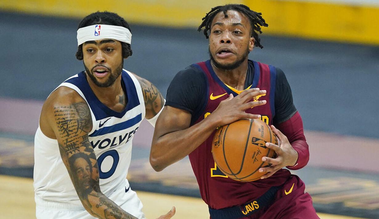 Pebasket Cleveland Cavaliers, Darius Garland, berusaha melewati pebasket Minnesota Timberwolves, D'Angelo Russell, pada laga NBA di Rocket Mortgage FieldHouse, Senin (1/2/2021). Cavaliers menang dengan skor 100-98. (AP/Tony Dejak)