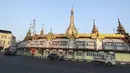 Kendaraan melewati Pagoda Sule di Yangon saat militer Myanmar merebut kekuasaan pemerintah, Senin (1/2/2021). Rekaman video yang disiarkan di televisi milik militer mengatakan kekuasaan telah diserahkan kepada panglima tertinggi militer Myanmar, Jenderal Senior Min Aung Hlaing. (AP Photo/Thein Zaw)