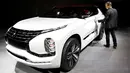 Seorang jurnalis melihat Mitsubishi GT PHEV Concept saat ditampilkan di Paris Auto Show di Paris, Prancis (29/9). (REUTERS/Benoit Tessier)