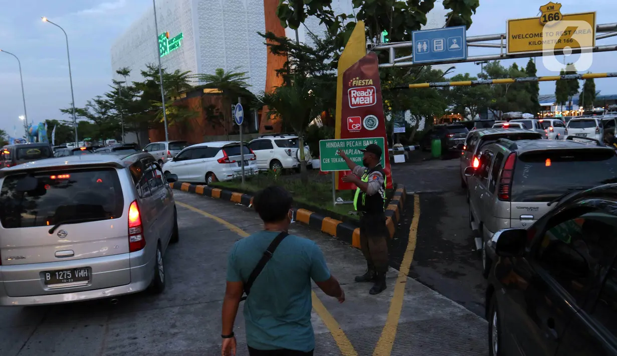 <p>Petugas mengatur lalu lintas kendaraan yang akan memasuki rest area di KM 166 Jalan Tol Cikopo - Palimanan, Jawa Barat, Rabu (27/4/2022). Memasuki H-5 Lebaran, volume kendaraan di Jalan Tol Cikopo - Palimanan mengalami peningkatan signifikan yang mengakibatkan kemacetan pada sejumlah ruas jalan utama tol karena antrean kendaraan yang akan masuk rest area. (Liputan6.com/Herman Zakharia)</p>