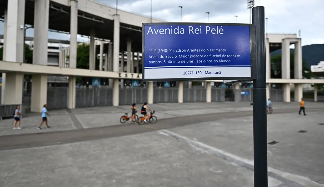 Sebuah tanda jalan bertuliskan "King Pele Avenue" digambarkan di luar stadion Maracana di Rio de Janeiro, Brasil pada 4 Januari 2023. Balai Kota Rio de Janeiro secara resmi menamai jalan yang mengelilingi stadion Maracana Avenue Rei Pele (King Pele). (MAURO PIMENTEL/AFP)