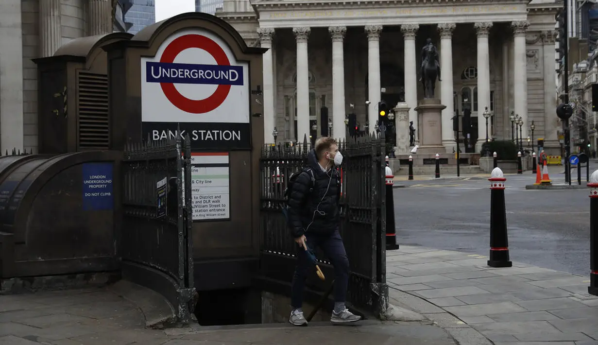Seorang pria berjalan keluar dari stasiun kereta bawah tanah pada pagi pertama penerapan lockdown nasional ketiga di Kota London, Inggris, 5 Januari 2021. Inggris memasuki lockdown nasional ketiga sejak pandemi virus corona COVID-19 dimulai. (AP Photo/Matt Dunham)