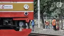 Pekerja PT KAI menyelesaikan pemasangan pembatas jalan di perlintasan kereta tanpa palang pintu di kawasan TPU Tanah Kusir, Jakarta, Kamis (17/9/2020). Pemasangan pembatas jalan dilakukan untuk mencegah kecelakaan kendaraan yang sering terjadi di kawasan tersebut. (merdeka.com/Iqbal S. Nugroho)